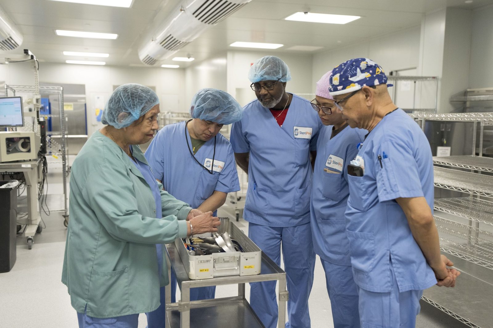SteriPro technicians and educator reviewing an instrument set together